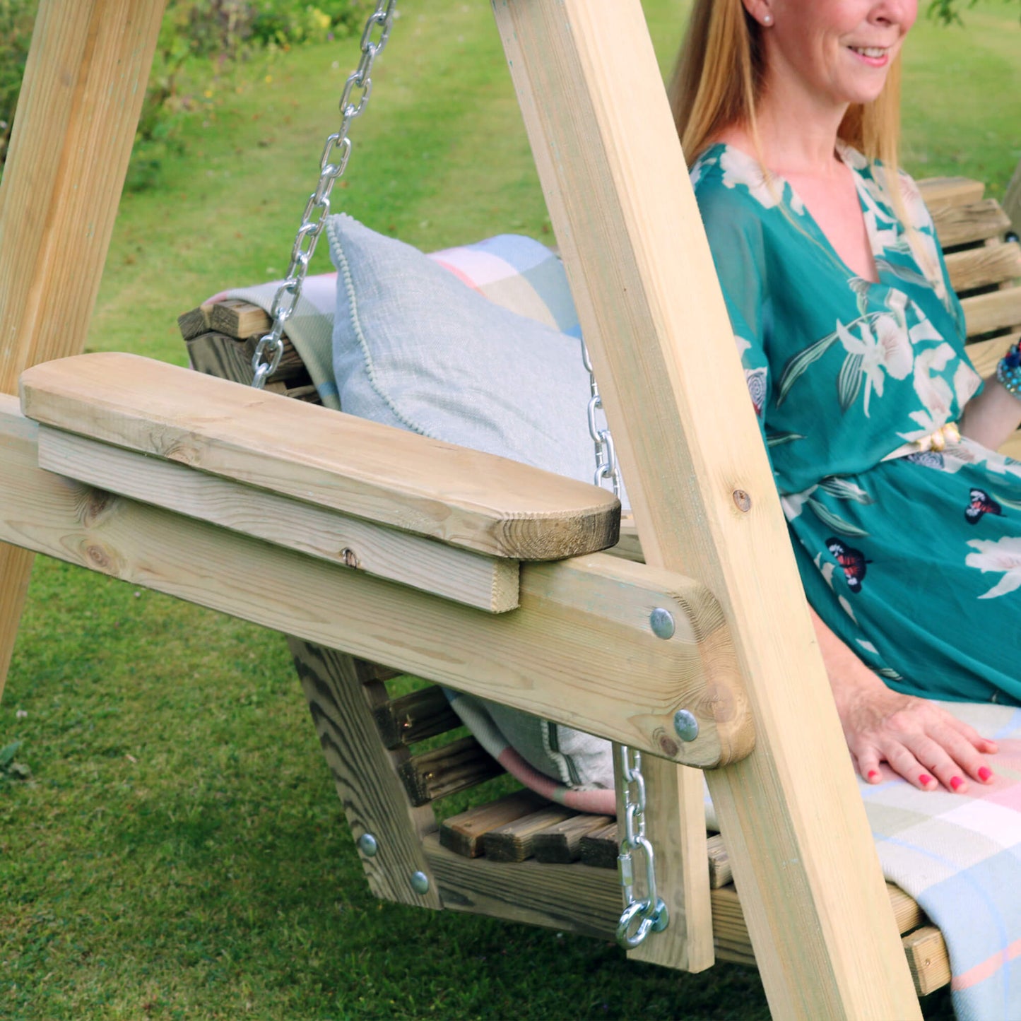 Woman sitting on a wooden swing in a garden