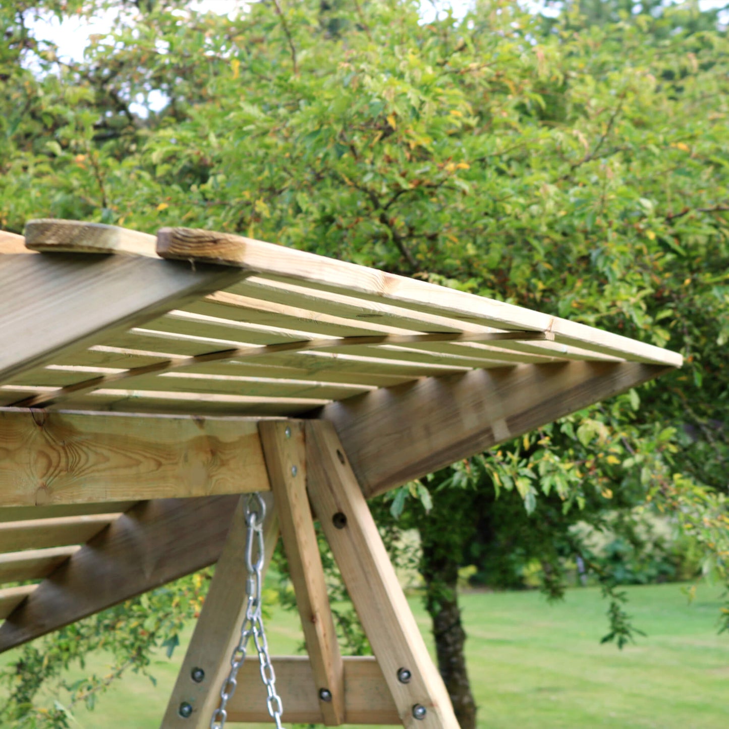 Wooden swing set with greenery in the background
