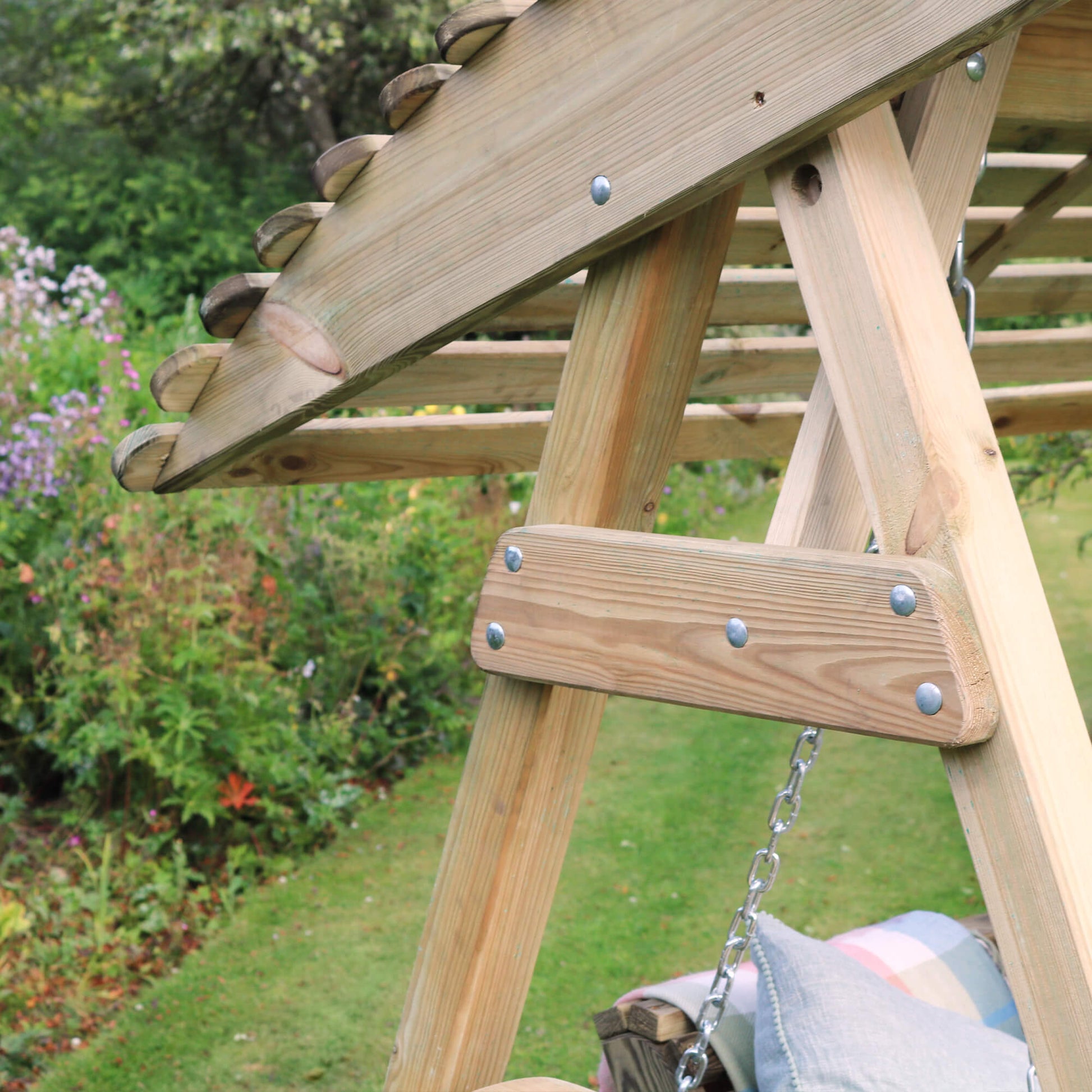 Wooden swing set with a child on it in a garden setting